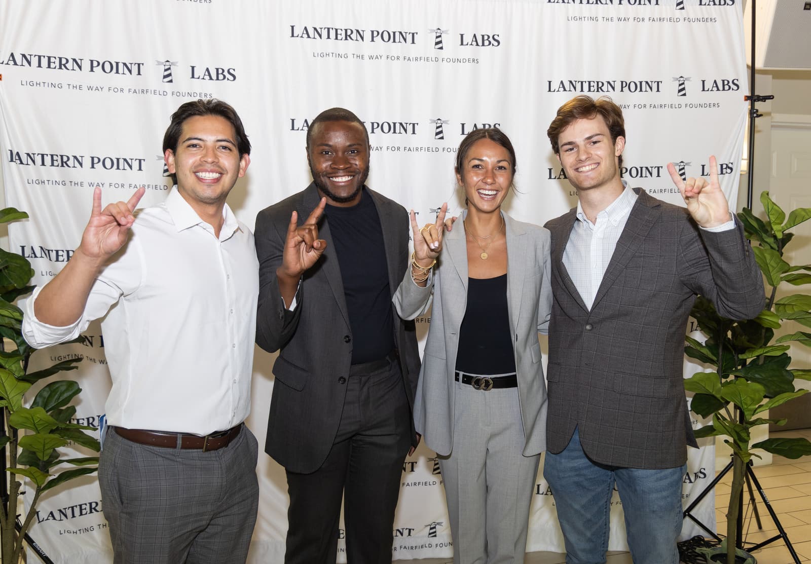 Four smiling Associates in front of the Lantern Point Labs backdrop