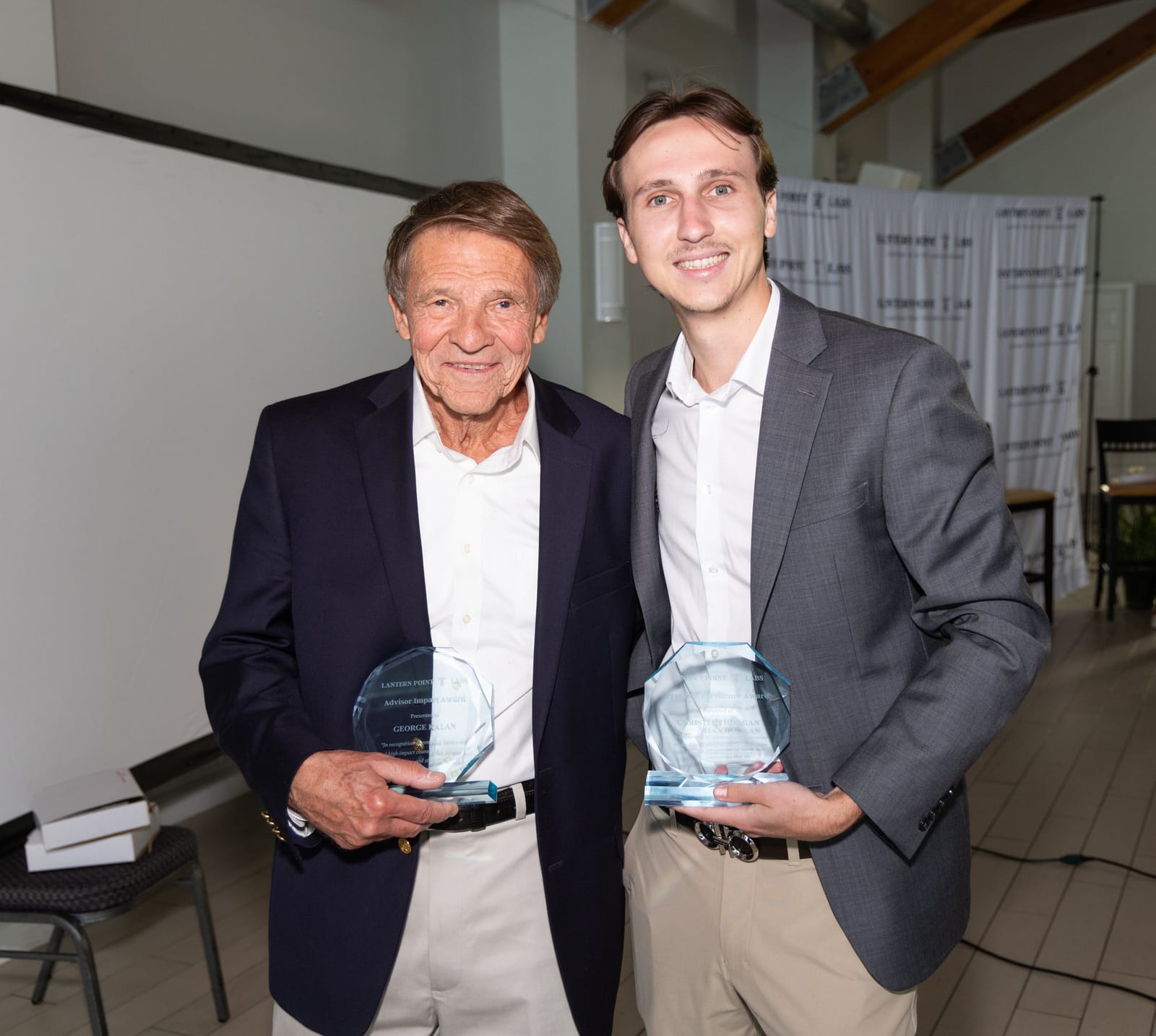 George Kalan holds his Advisor Impact Award beside a member of the LPL team