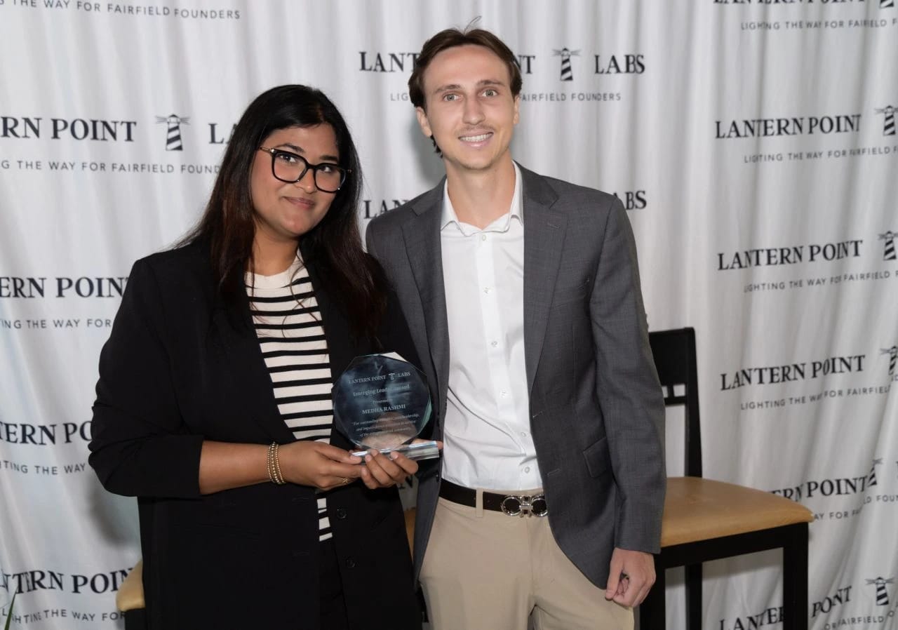 Medha Rashmi holds her Emerging Leader Award in front of the Lantern Point Labs backdrop